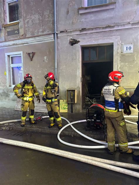 Schemat działań ratowniczo-gaśniczych w budynku wielorodzinnym: ewakuacja, kurtyny dymowe, zabezpieczenie lokatorów.