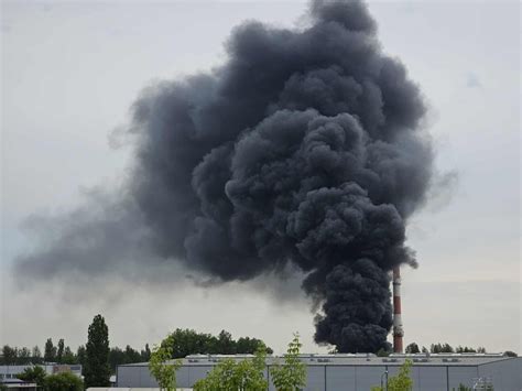 Zdjęcie dymu unoszącego się nad dachem budynku w Toruniu