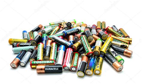 zdjęcie pokazujące ręce trzymające zużyte baterie i symbol recyklingu