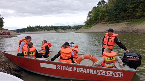 Zdjęcie przedstawiające strażaków w woderach lub na łodzi ratujących ludzi podczas powodzi