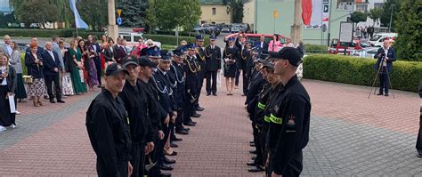 Szpaler strażaków z toporkami tworzących łuk dla Młodej Pary