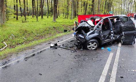 Zdjęcie z miejsca wypadku drogowego w Połomi, ukazujące zderzone samochody i uszkodzony budynek mieszkalny