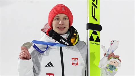 Zdjęcie Zbigniewa Bródki na podium olimpijskim z medalem