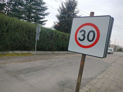 Znak drogowy ograniczenia prędkości i sylwetka strażaka w tle