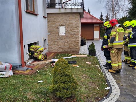 Zdjęcie przedstawiające akcję gaśniczą w budynku mieszkalnym lub strażaków ewakuujących mieszkańców