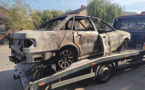 spalony samochód BMW na parkingu leśnym