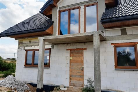 Infografika przedstawiająca kluczowe etapy termomodernizacji budynku, takie jak docieplenie ścian i wymiana dachu oraz okien.