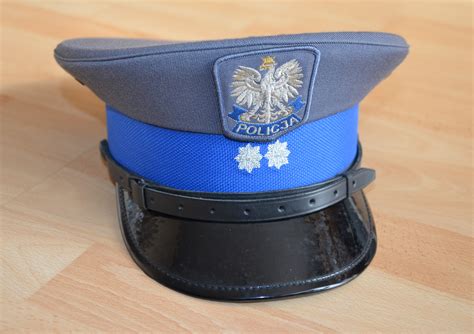 Grafika przedstawiająca różne symbole związane z pracą policji: policyjna czapka, policyjna tarcza, radiowóz.