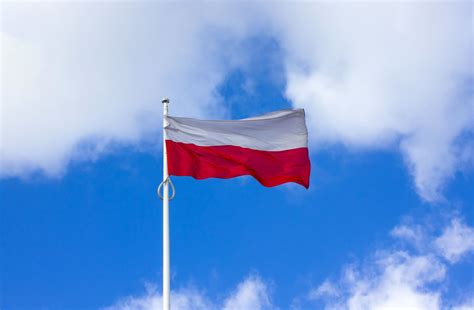 zdjęcie: flaga Polski na maszcie w pozycji do połowy masztu podczas żałoby narodowej