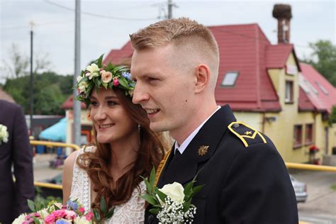 Brama weselna z węży strażackich udekorowana hełmami i wstążkami