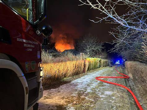 Strażacy gaszący pożar na ogródkach działkowych w pobliżu stacji paliw, widok z lotu ptaka lub z ziemi