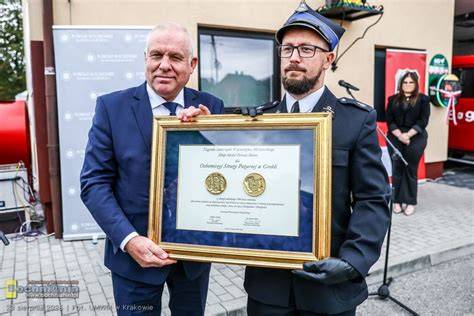 zdjęcie nagrody Złota Polonia Minor, wicemarszałek wręczający nagrodę strażakom OSP Grobla