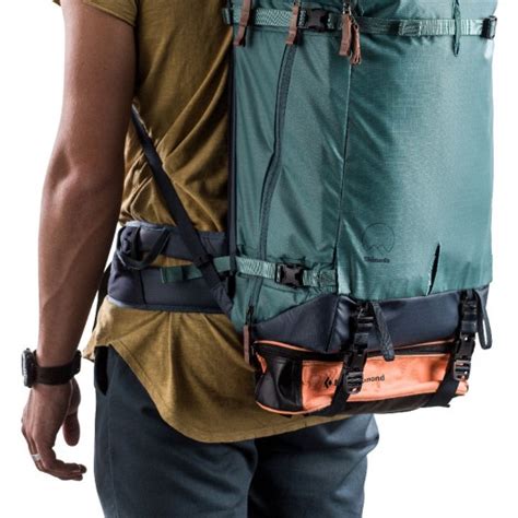 Ilustracja pokazująca regulację pasków naramiennych plecaka oraz sposób jego zawieszenia na uchwycie.