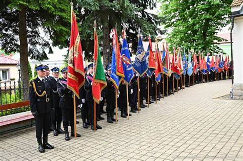 Zdjęcie grupowe strażaków z nowym sztandarem przed kościołem