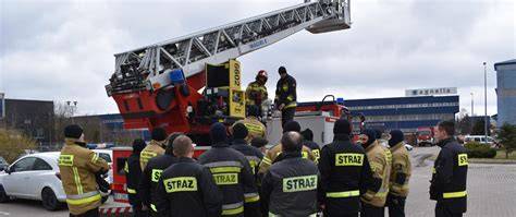 Zdjęcie strażaków gaszących pożar z drabin mechanicznych