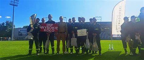 Zgromadzenie jednostek OSP przed zawodami na boisku sportowym