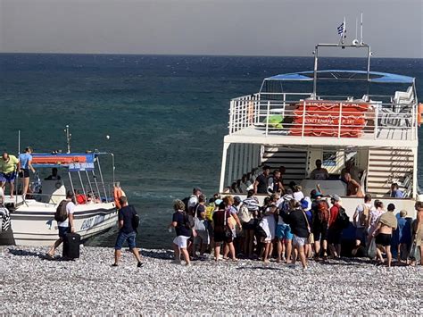 Zdjęcie przedstawiające dym nad Rodos lub scenę ewakuacji turystów z plaży