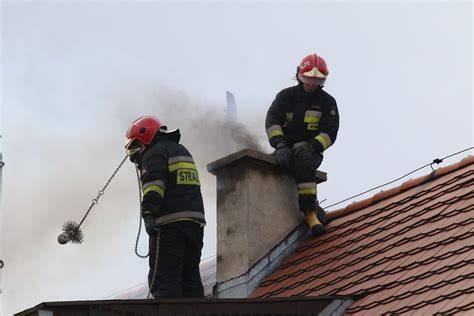 zdjęcie strażaka używającego lancy mgłowej do gaszenia pożaru sadzy w kominie