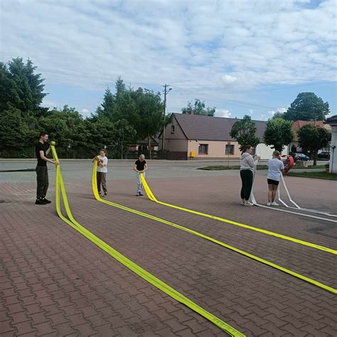 Zdjęcie z zawodów sportowo-pożarniczych - drużyna w trakcie sztafety lub ćwiczenia bojowego