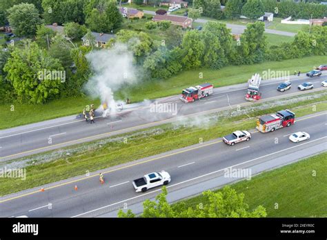 Thematic photo of a car fire on a highway rest area, with police present.