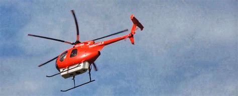 Czerwony helikopter ratunkowy lub strażacki w akcji gaśniczej
