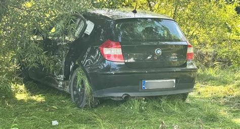 Zdjęcie spalonego samochodu BMW na poboczu drogi