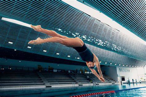 Fotografia przedstawiająca profesjonalnego skoczka do wody w trakcie skoku z trampoliny