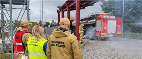 Zdjęcie przedstawiające akcję gaśniczą straży pożarnej na terenie hali przemysłowej