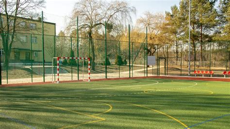 widok na boisko Szkoły Podstawowej nr 7 w Gnieźnie z widoczną tablicą upamiętniającą kirkut