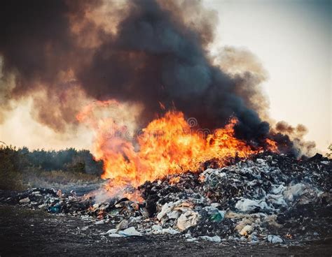Drone shot of a large industrial fire or a waste dump fire with thick smoke