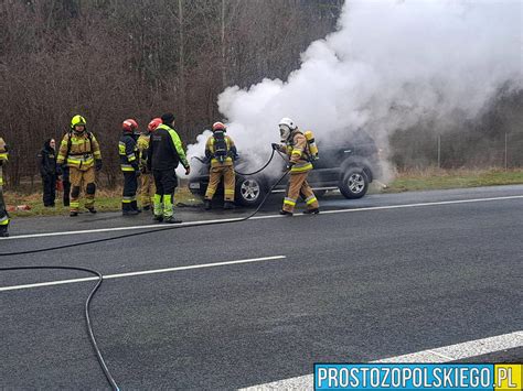 fotografia płonącego samochodu osobowego na poboczu drogi w pobliżu węzła autostradowego A4