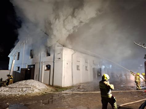 Widok na zniszczony budynek stadniny koni w Mosznej po pożarze, z widocznym spalonym dachem