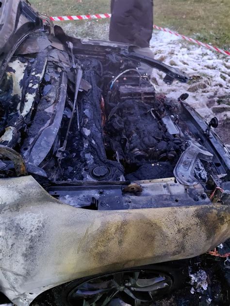 Zdjęcie spalonego samochodu dostawczego na parkingu osiedlowym w Rybniku-Boguszowicach, w tle uszkodzone inne pojazdy