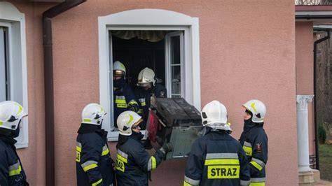 Strażacy OSP w akcji ratowniczej gaszący pożar i udzielający pomocy
