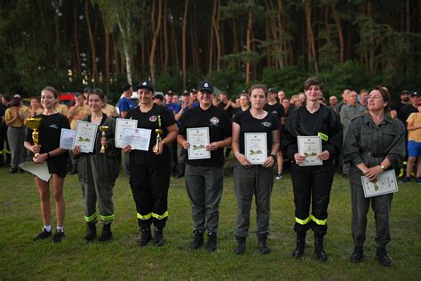 Zdjęcie grupowe młodych strażaków podczas ceremonii otwarcia zawodów w hali sportowej.