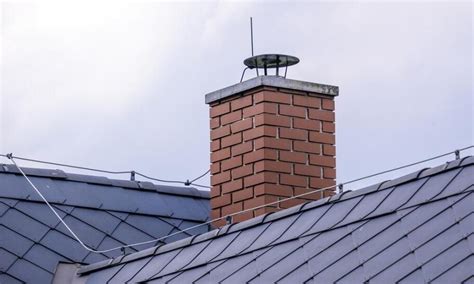 Ilustracja przedstawiająca wpływ wiatru na ciąg wsteczny i sposób montażu nasady kominowej
