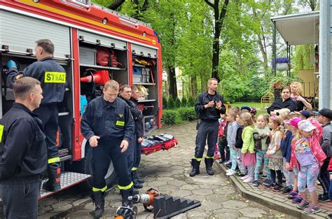 Ilustracja przedstawiająca Strażaka Sama w wozie strażackim, zachęcająca dzieci do wspólnej zabawy