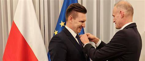 Fotografia z uroczystości jubileuszowej, wręczenie medalu oraz zgromadzeni druhowie