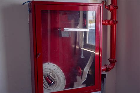 Thematic photo of a red internal hydrant cabinet in an industrial setting, possibly a workshop