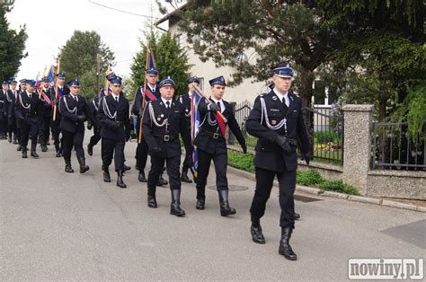 Zdjęcie przedstawiające uroczysty apel strażacki z pocztami sztandarowymi i orkiestrą dętą