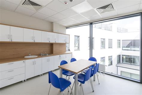 Ilustracja przedstawiająca drewnianą remizę strażacką z elementami takimi jak garaż, pomieszczenie socjalne i lądowisko dla helikoptera.