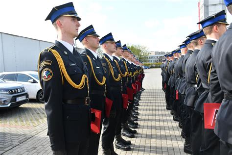 Kompania honorowa straży pożarnej z toporkami przy pasie