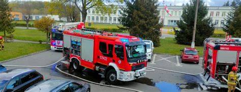 ludzie uczestniczący w ćwiczeniach ewakuacyjnych z budynku