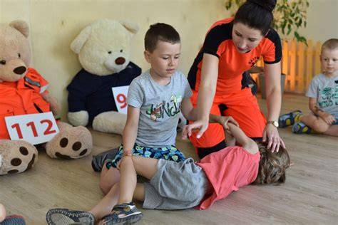 Dzieci uczące się pierwszej pomocy na pikniku