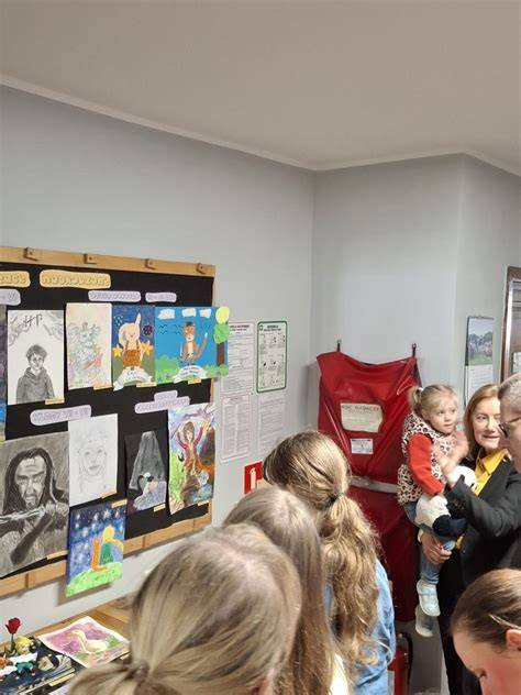 Zdjęcie przedstawiające wystawę prac plastycznych dzieci na temat zimy lub scenę z rozstrzygnięcia konkursu w hali sportowej.