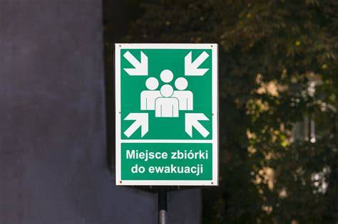 Ilustracja przedstawiająca dwóch policjantów pomagających w ewakuacji osoby niepełnosprawnej podczas pożaru