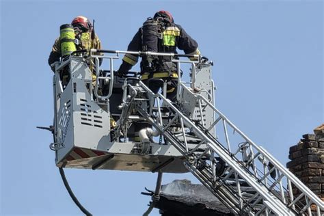 strażacy gaszący pożar dachu z drabiny mechanicznej