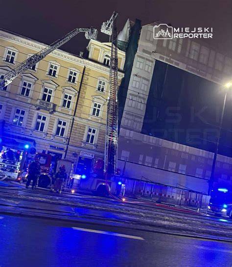 Strażacy używający drabin przenośnych na dachu budynku