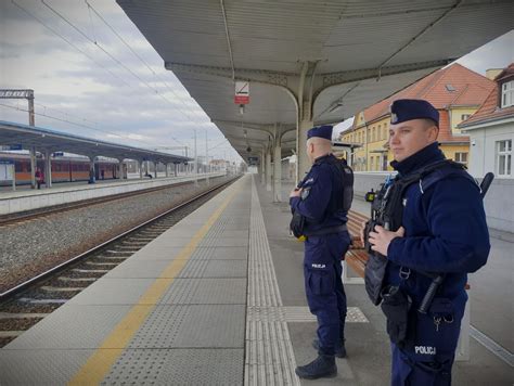 Funkcjonariusze Policji i strażacy pracujący na miejscu pożaru w nocy
