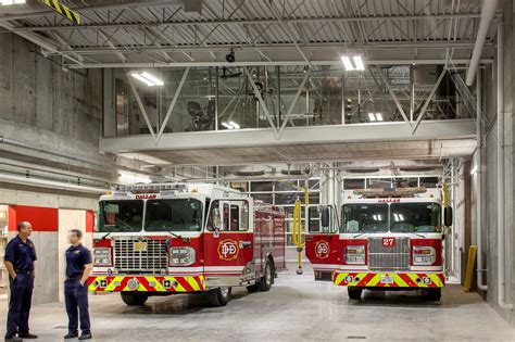 Thematic photo of a fire truck parked inside a fire station bay, without any people present.